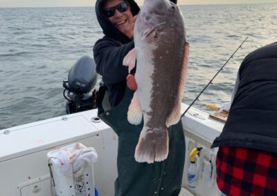 a person holding a fish on a boat